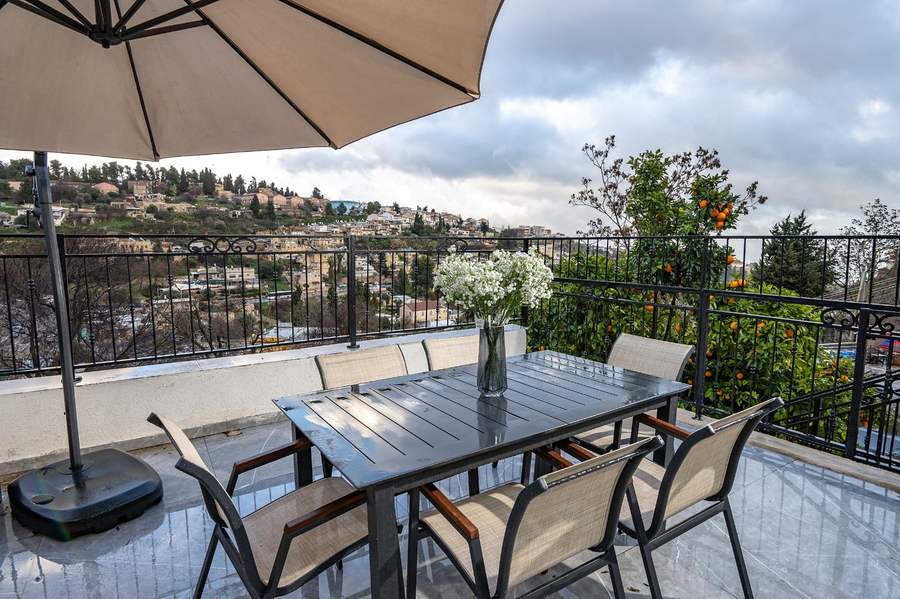Terrace dining table with citrus trees and view