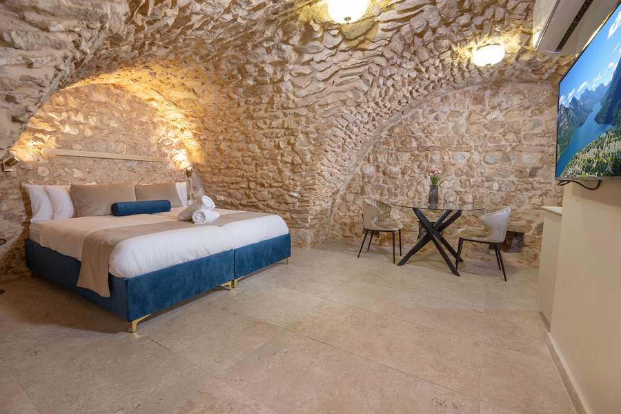 Suite bedroom under a vaulted stone ceiling