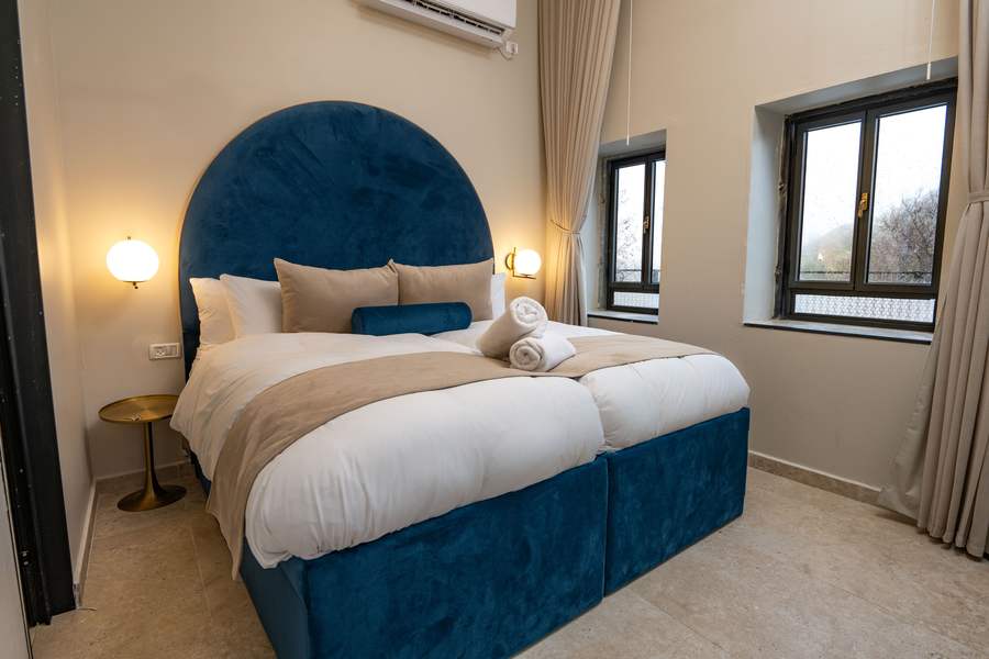 Suite bedroom with arched blue headboard